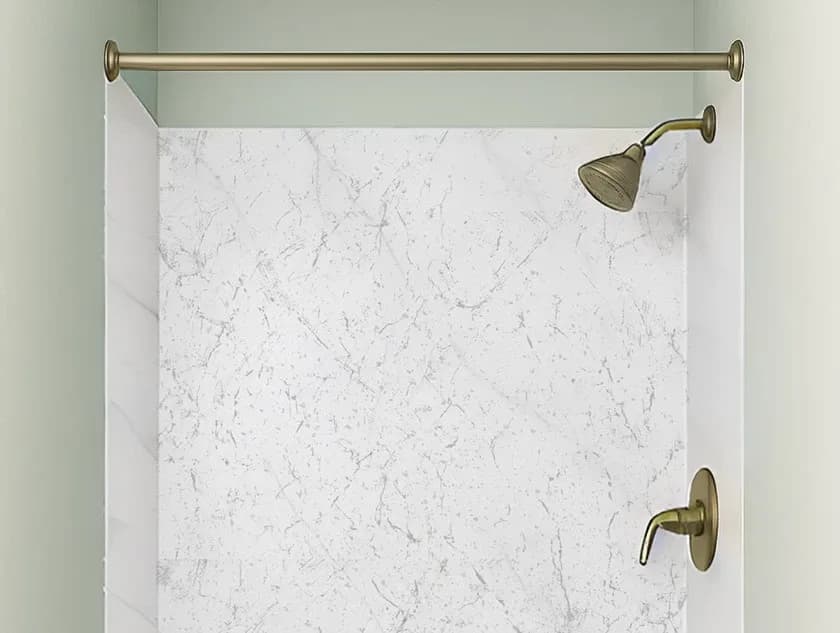 Shower area with a marble-patterned wall, bronze shower head, and matching faucet. A bronze rod is mounted above for a curtain.