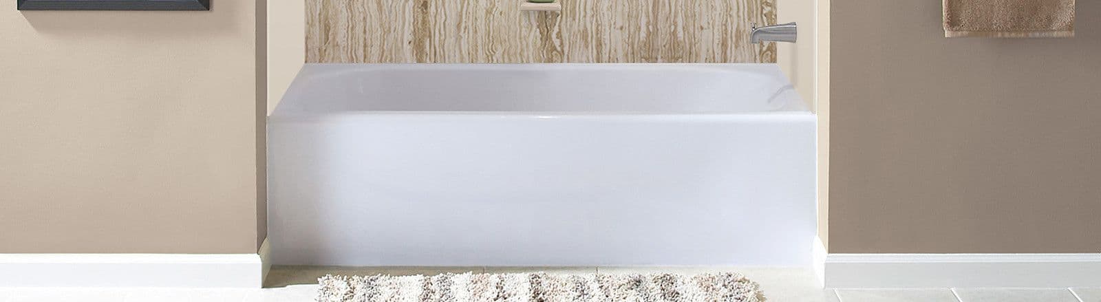 A modern bathroom with a white bathtub and beige walls. A textured rug lies on the floor, and the tub's wall features a wood-like panel.