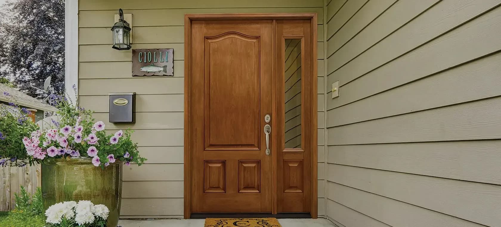 A tan house with a brown entry door with a single lite on the right-hand side.