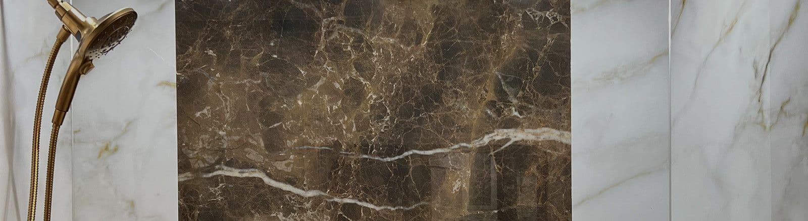 Gold showerhead with white and brown marble tiles in a modern bathroom.