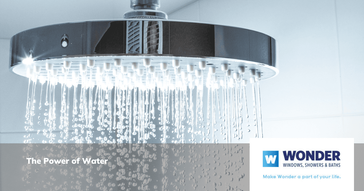 Modern showerhead with cascading water in a bright bathroom. Text overlay says "The Power of Water." Brand logo reads "Wonder Windows, Showers & Baths."