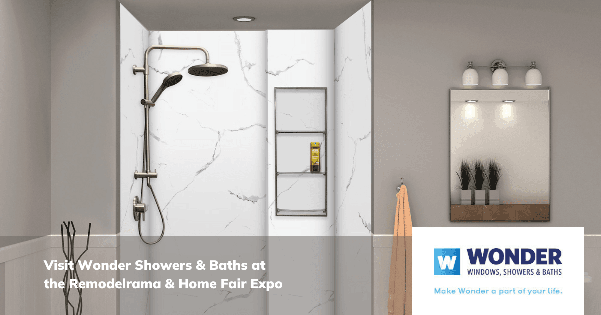 Modern bathroom with a marble shower, black fixtures, and a recessed shelf. A mirror and small plant sit on a wooden shelf. Wonder Showers & Baths logo.