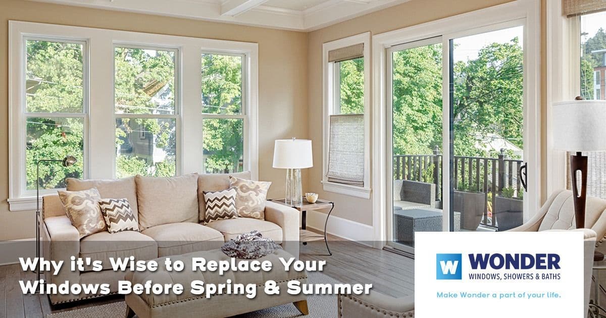 Bright living room with large windows letting in natural light, beige sofa, and modern decor. Text reads "Why it's Wise to Replace Your Windows Before Spring & Summer." Logo: Wonder Windows.