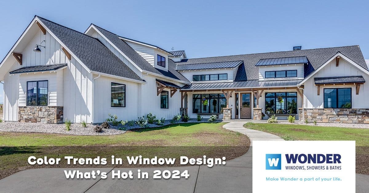 Spacious modern farmhouse with white siding and dark windows under clear blue sky. Text: "Color Trends in Window Design: What's Hot in 2024."