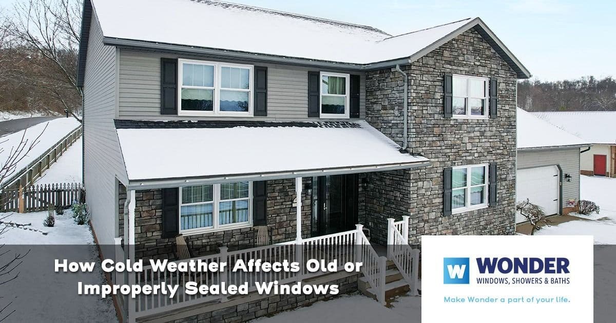 A two-story house with stone and siding, snow-covered roof, and yard, showcasing potential vulnerabilities of windows in cold weather. Text: "How Cold Weather Affects Old or Improperly Sealed Windows."