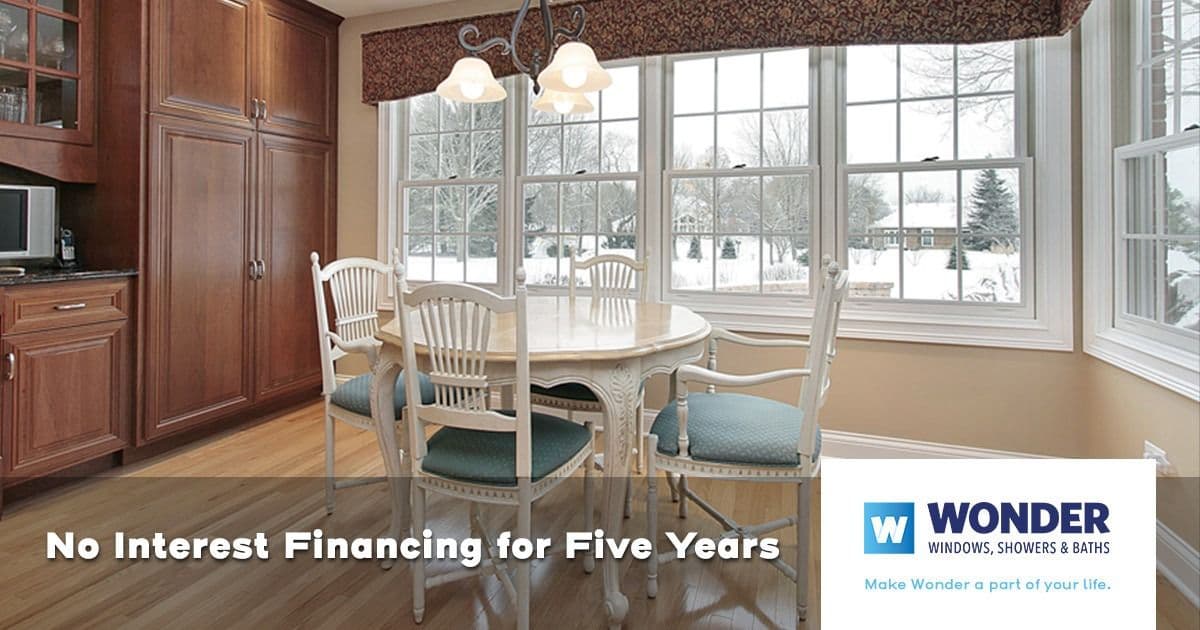 A cozy dining area with a white table and chairs overlooks a snowy backyard through large windows. Text overlay: "No Interest Financing for Five Years."
