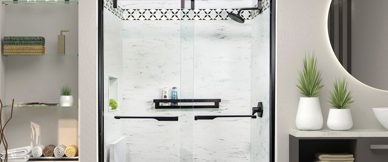 Modern bathroom with a glass shower featuring black accents and a decorative tile trim. Shelves with neatly stacked towels and potted plants enhance the elegant, serene atmosphere.