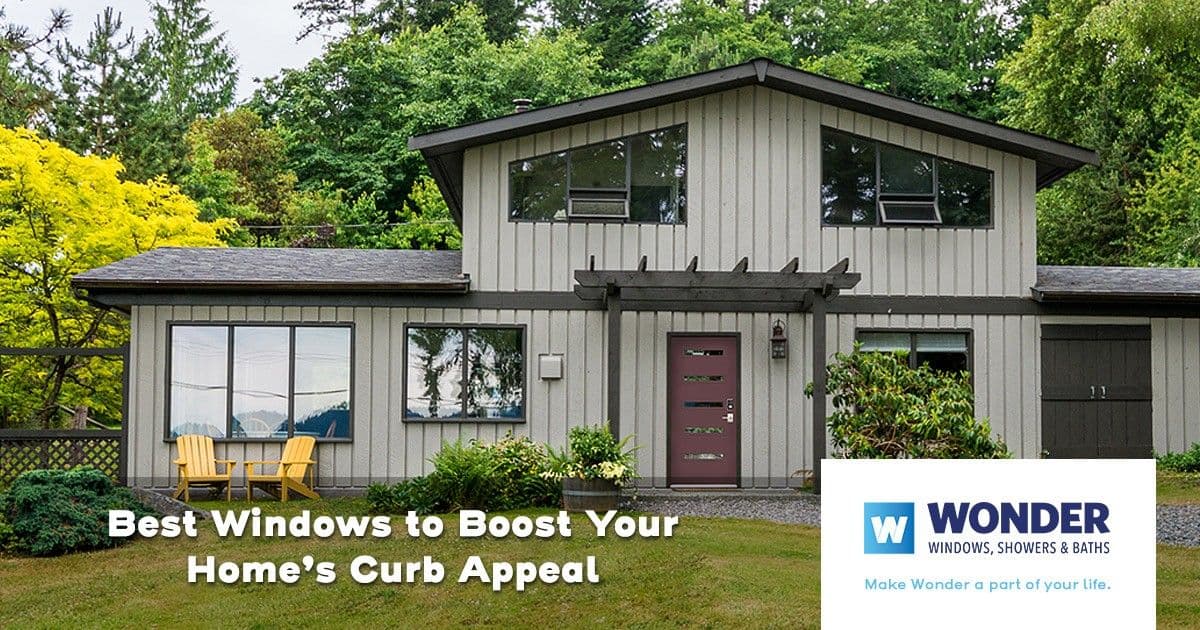 Modern gray house with large windows, surrounded by lush greenery. A "Wonder Windows, Showers & Baths" logo is at the bottom right. Text reads, "Best Windows to Boost Your Home’s Curb Appeal."